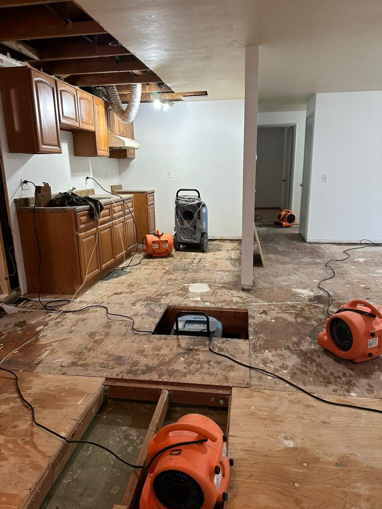 Water damage restoration in progress with air movers and dehumidifier.
